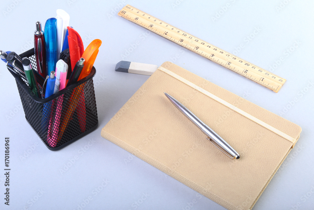 Colorful notebooks and office supplies on white table.