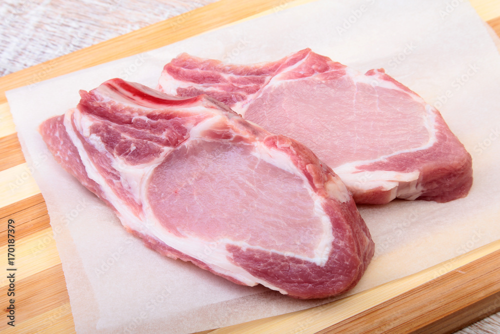 Raw pork chops, spices on cutting board. Ready for cooking. Raw pork chops, spices on cutting board. Ready for cooking.