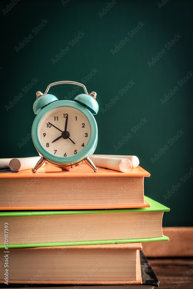 Alarm clock on stack of books Alarm clock on stack of books