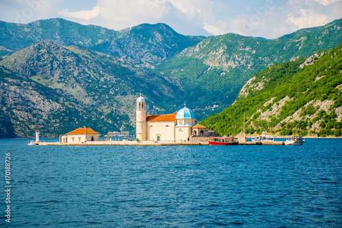 The yacht sails near the picturesque Gospa od Skrpela Island in the Boka Kotorsky Bay. photo