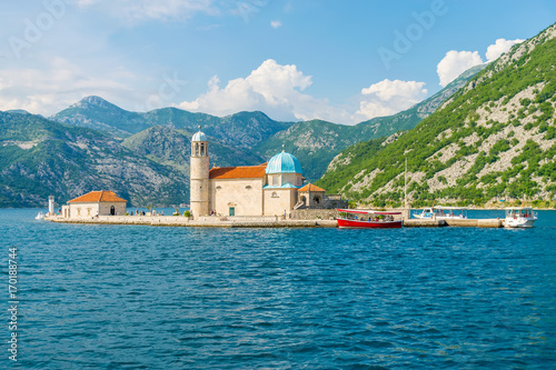 The yacht sails near the picturesque Gospa od Skrpela Island in the Boka Kotorsky Bay. photo