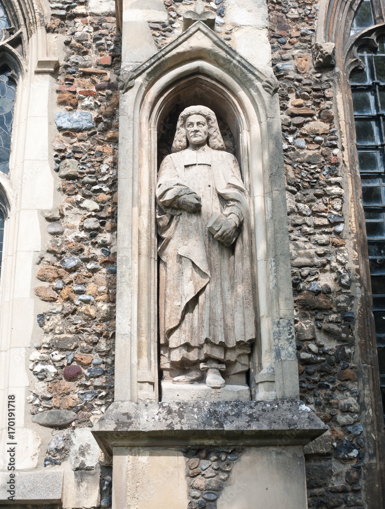 Fototapeta premium statue of judge man on the outside of english christian church made of stone