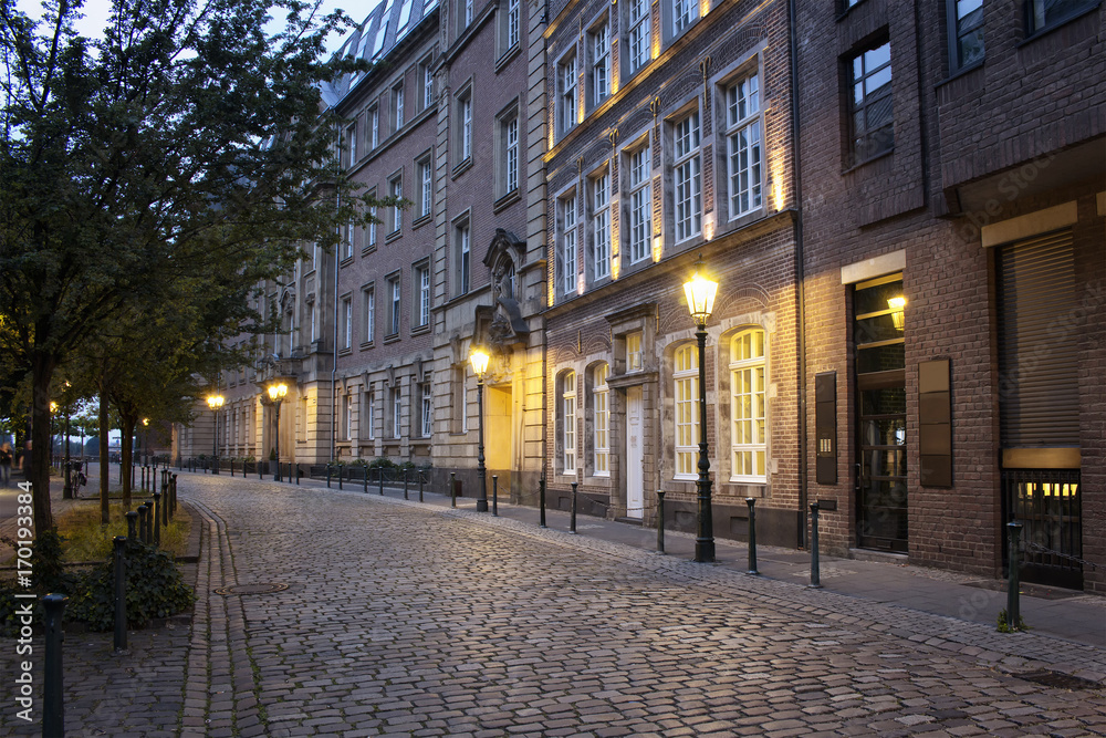 Evening view of old, historical buildings and cobblestone street in Altstadt Dusseldorf.