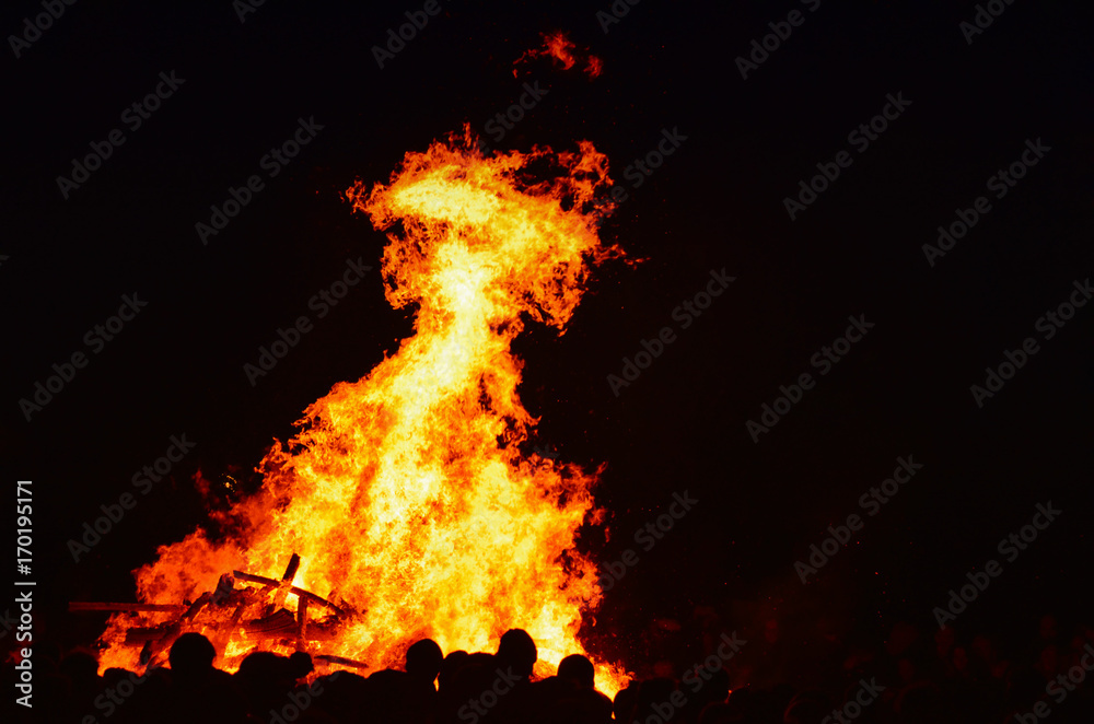 Fire at night with people in a festival