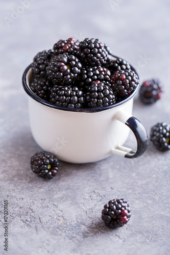Juicy fresh blackberries in a mug. Organic healthy berries. Selective focus