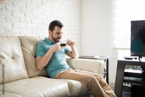 Man sitting alone in the living room with a cappuccino