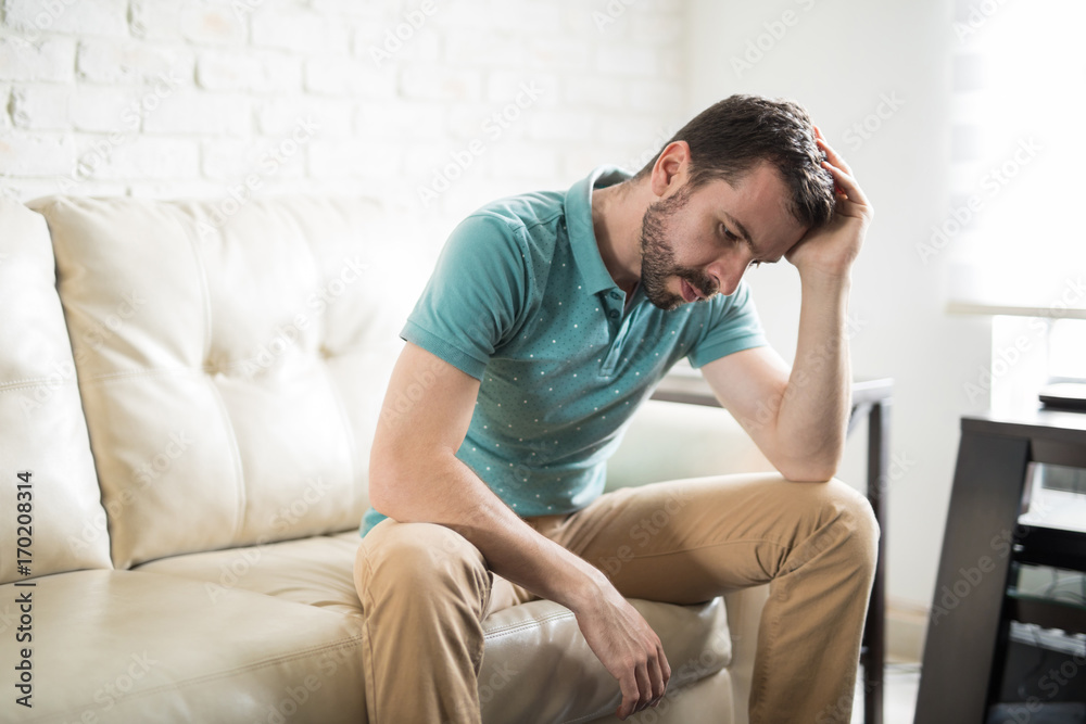 Attractive man worried and alone at home