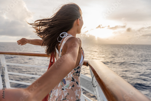 Cruise ship vacation travel woman enjoying freedom. Holiday tourist with open arms in front of boat feeling carefree in the tropical wind .