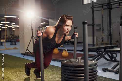 sled push woman pushing weights workout exercise photo