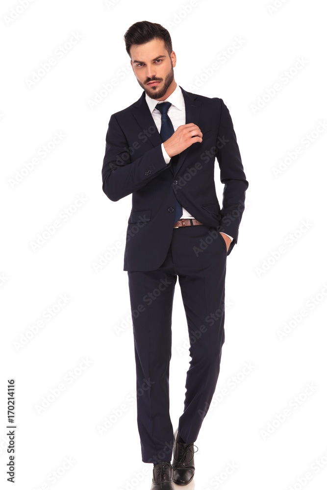 confident young business man fixing his chest pocket confident young business man fixing his chest pocket