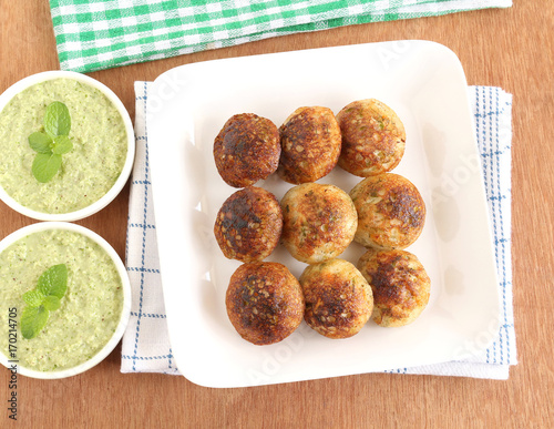 Paddu, south Indian vegetarian food, is usually made from a batter of lentils and rice, and coconut chutney. photo