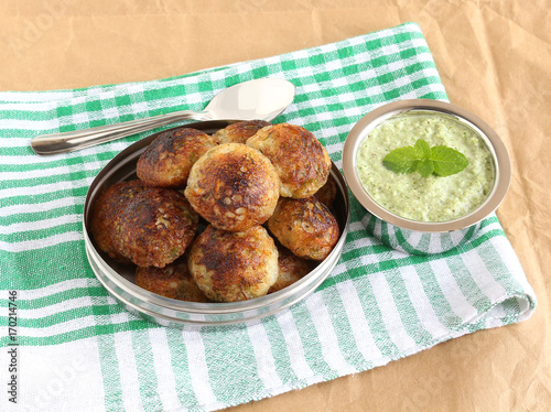 Paddu, south Indian vegetarian food, is usually made from a batter of lentils and rice, and coconut chutney. photo