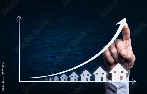 Business hand touching on a real estate graph.