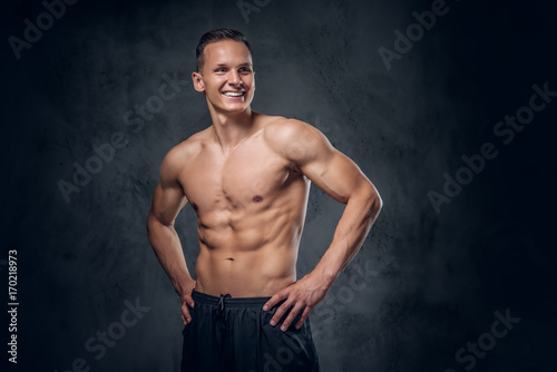 Shirtless sporty male on grey background.