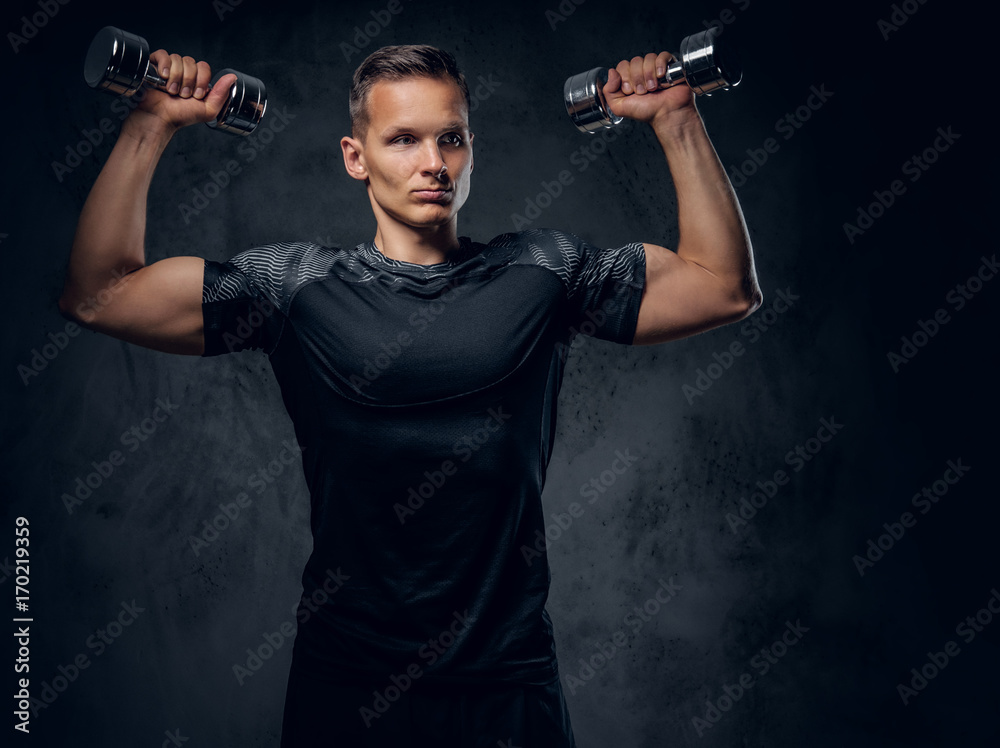 A man holds a set of dumbbells. A man holds a set of dumbbells.