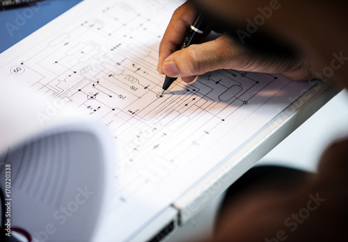 Fotografie Closeup of hand over circuit pattern guide line paper