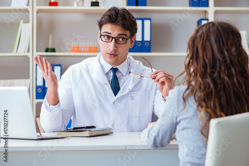 Doctor optician prescribing glasses to a patient