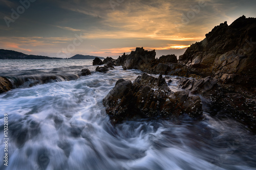 Beautiful Seascape with sea and rock on sunset background. © yingtanthawarak