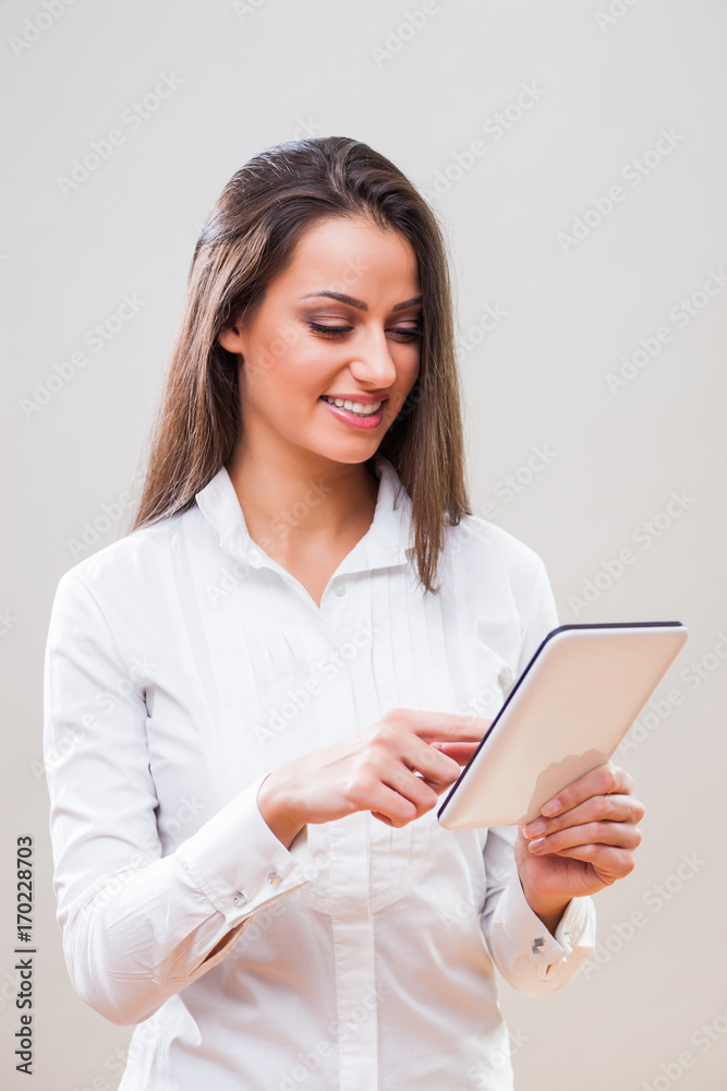 Studio shot portrait of young successful businesswoman who is using digital tablet. Studio shot portrait of young successful businesswoman who is using digital tablet.