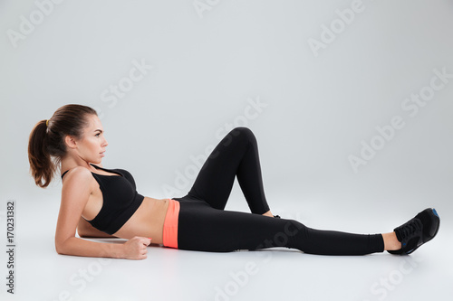 Side view of fitness woman lying on the floor