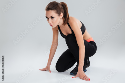 Serious fitness woman preparing to run in studio