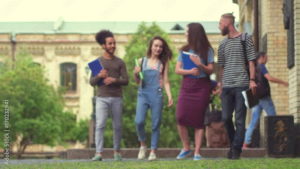 Students spending leisure time together, walking in campus. College friends taking a walk during break. Students spending leisure time together, walking in campus. College friends taking a walk during break.