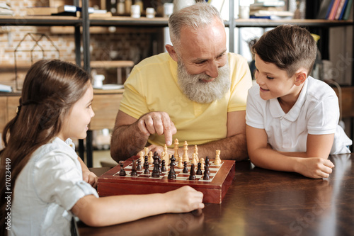 Grandfather suggesting his grandson next chess move photo