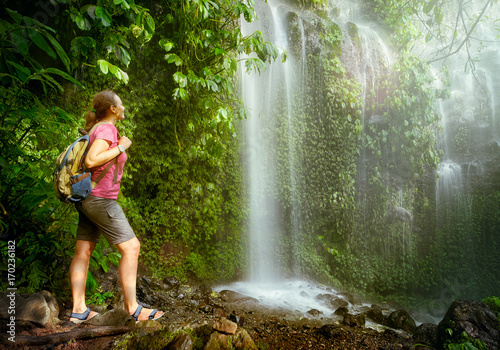 hiker looking at the waterfall in jungles.