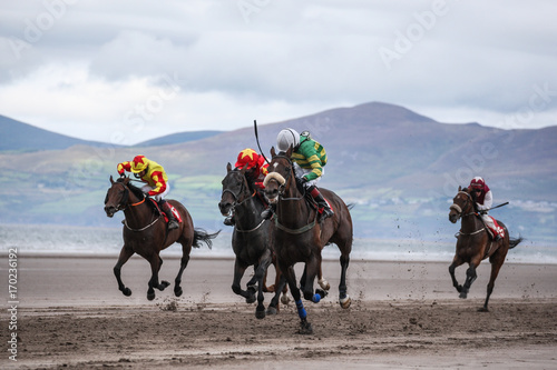 Race horses galloping on the beach 