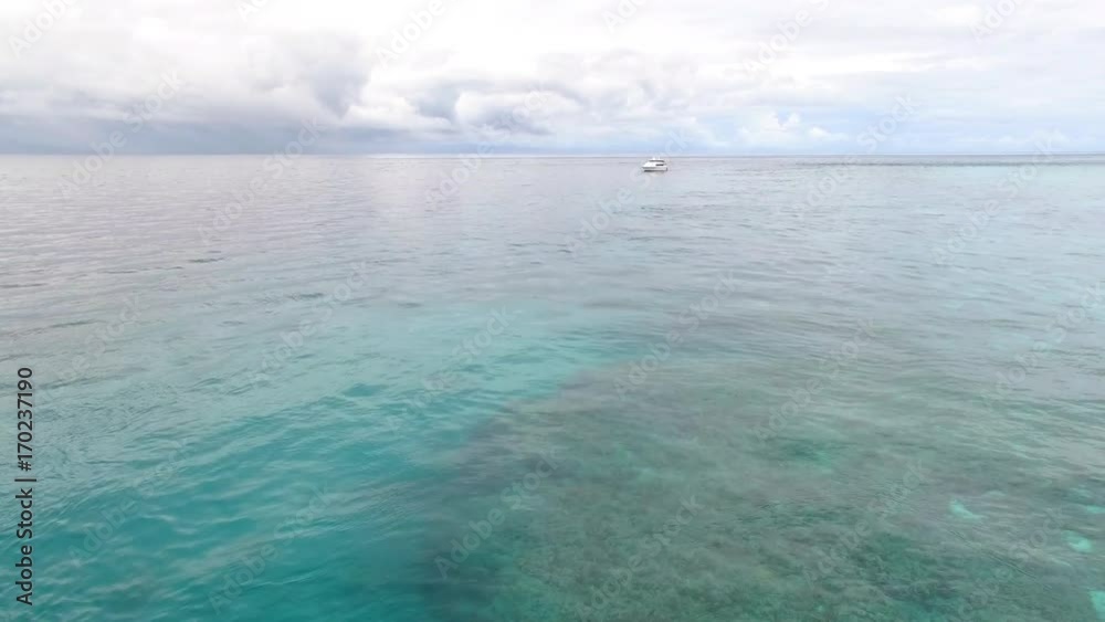 A wide shot of the ocean's horizon and sky. Shot showing a yacht.