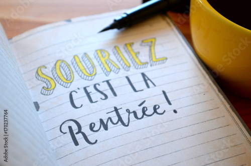 « SOURIEZ, C’EST LA RENTREE » lettrage à la main sur cahier