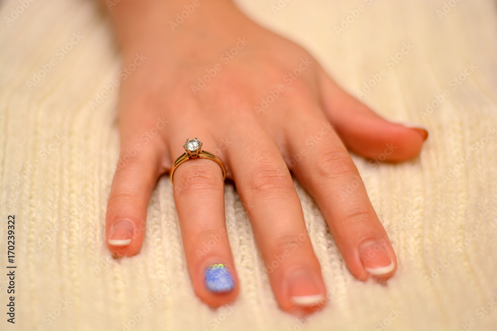 Photo of hand with wedding ring with diamond on white background