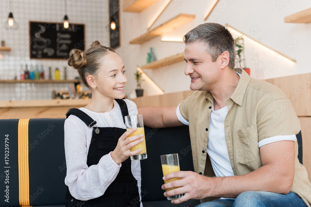 father and daughter with orange juice