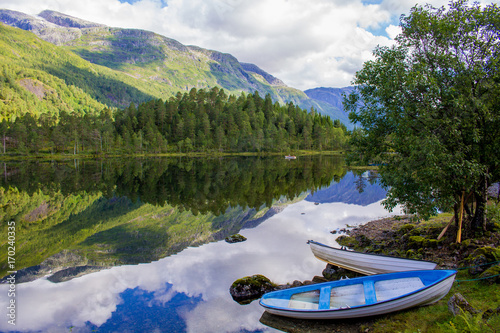 Fishing sailing boat on the lake in Norway fjord between the mountains.