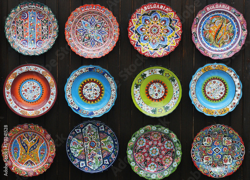 Colorful souvenirs hand painted ceramic plates on the wall in the bulgarian market
