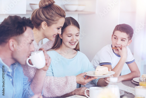 Positive family enjoying breakfast together