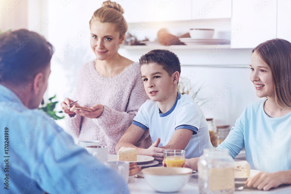 Obraz premium Adorable family listening to father talking during family meal