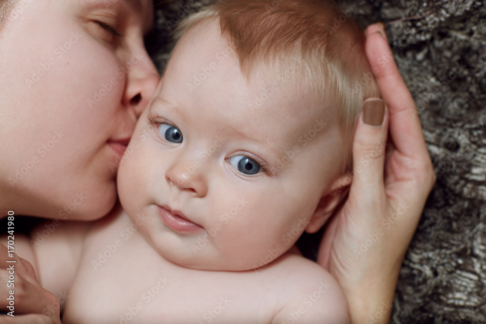 Close-up portrait of mother hugging her beautiful cute baby Close-up portrait of mother hugging her beautiful cute baby