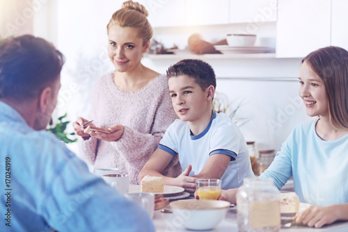 Adorable family listening to father talking during family meal