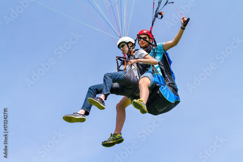 Instructor and paraglider flying in sky