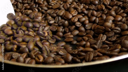 Man stirring fragrant coffee beans in frying pan