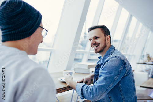 Men are sitting in front of the table near window