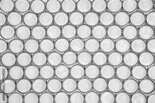 Crown cork bottle cap pattern background in black and white colours, aluminum texture lid of soda beverages