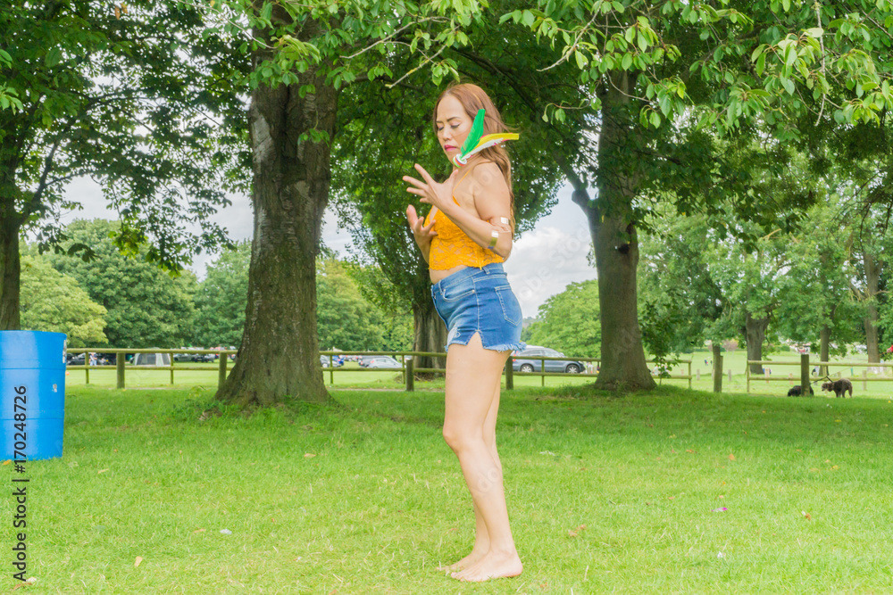 Filipino model plays a game kicking the feather in a local park in the summertime