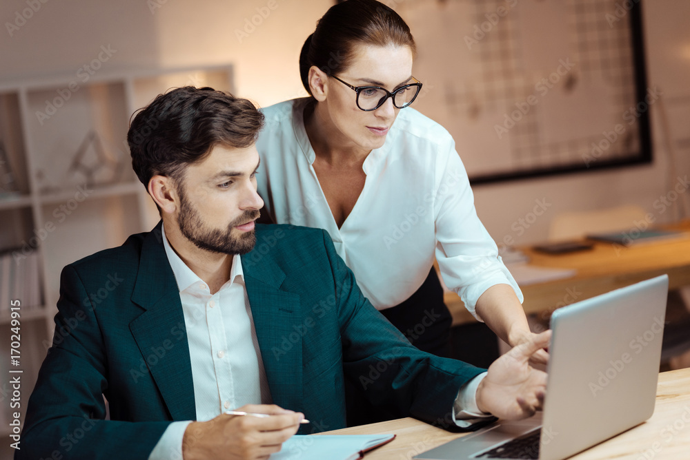 Attentive assistant standing behind her boss Attentive assistant standing behind her boss