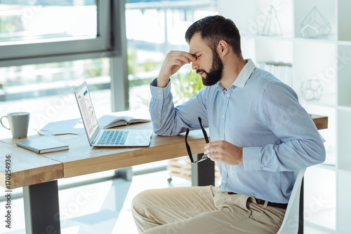 Tired businessman pinching bridge of nose