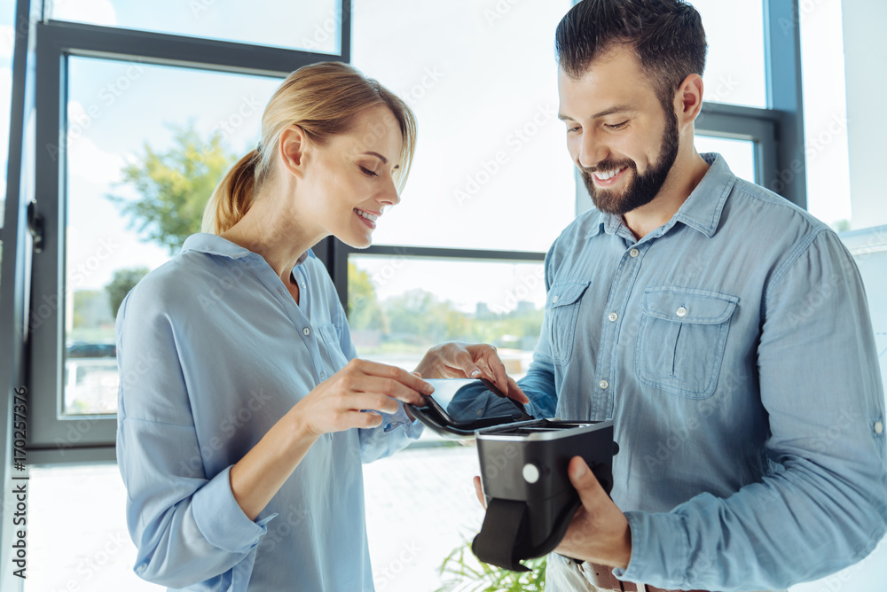 Smiling woman inserting phone into VR headset Smiling woman inserting phone into VR headset
