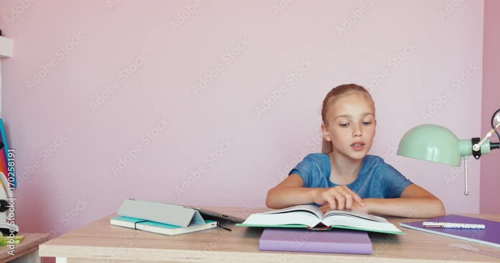 Cute student girl 9 aged doing homework in the bedroom. Dolly shot Cute student girl 9 aged doing homework in the bedroom. Dolly shot