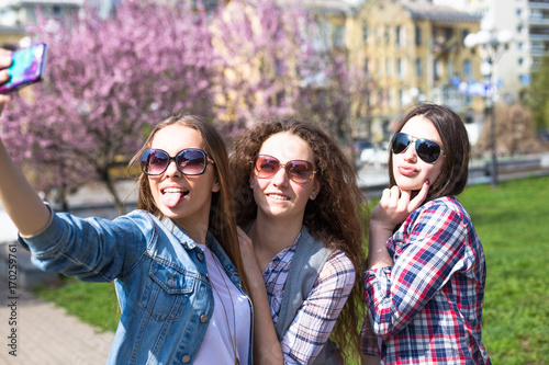 Happy teenage girls hawing fun spend time together in the city park