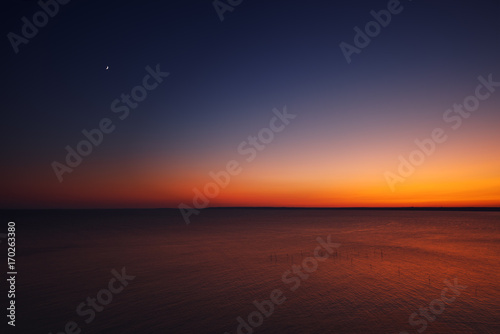 Golden sunset with moon over the black sea near cape Kaliakra, Bulgaria, aerial view